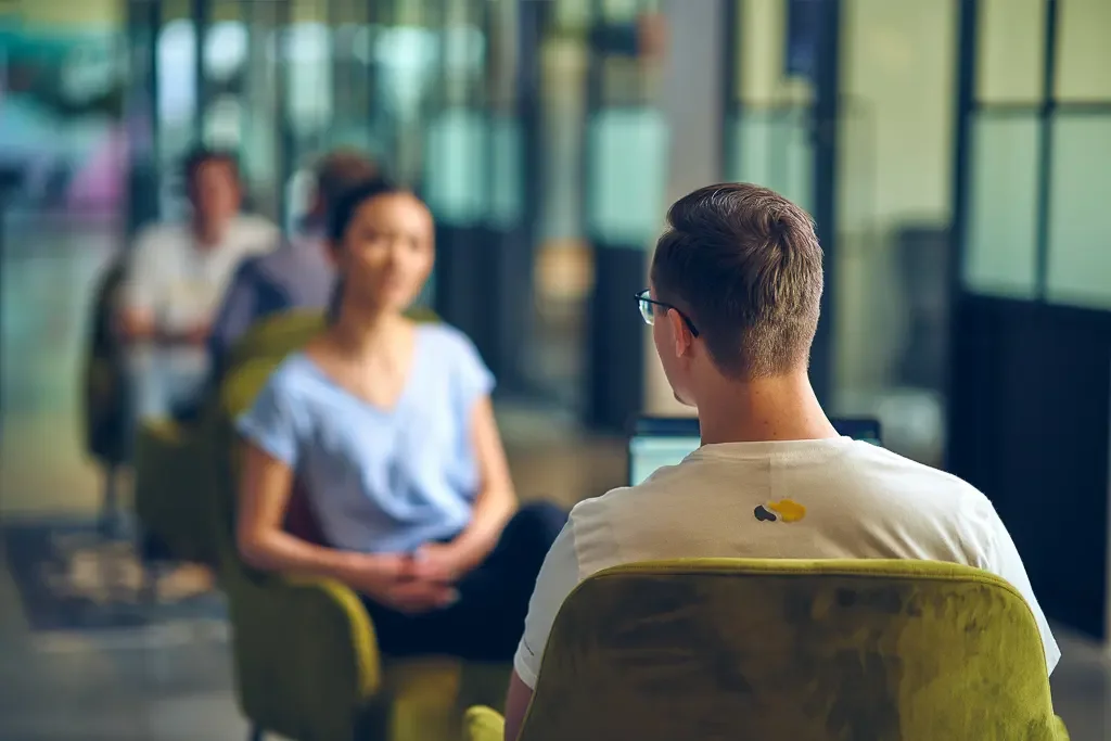 Colleagues having a conversation in a shared workspace.
